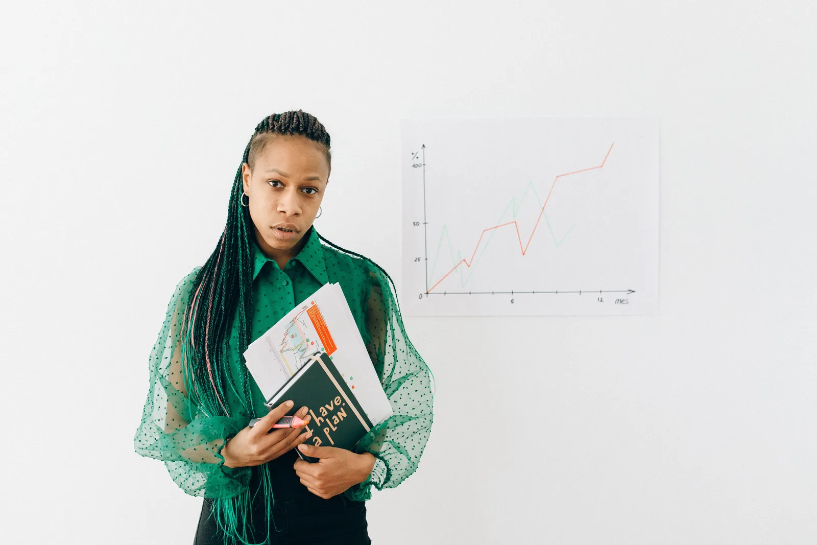 A professional woman stands confidently with documents and a graph, symbolizing business analysis. Employers that are good on pay tend to share four specific traits