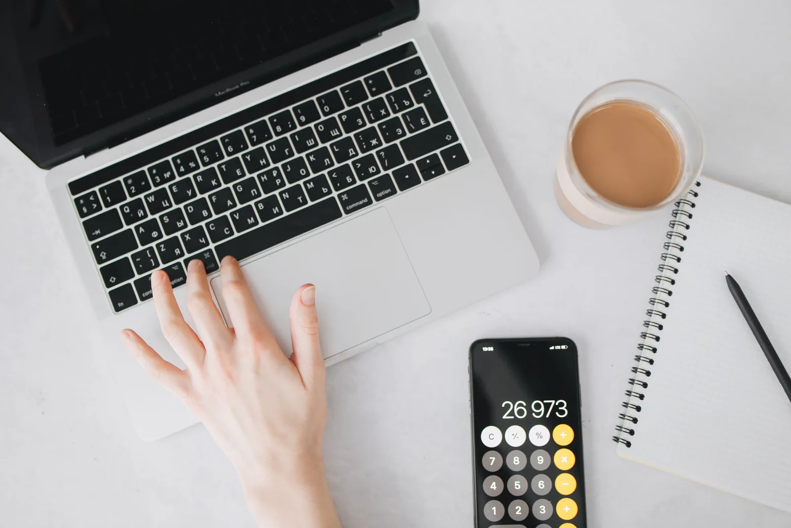 A person working on a laptop with a smartphone calculator and notebook nearby, ideal for business and technology themes. Salaries and advancement: how to influence decisions
