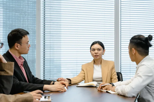 A diverse group of business professionals having a meeting around a conference table. Salaries and advancement career path: why pay plateaus